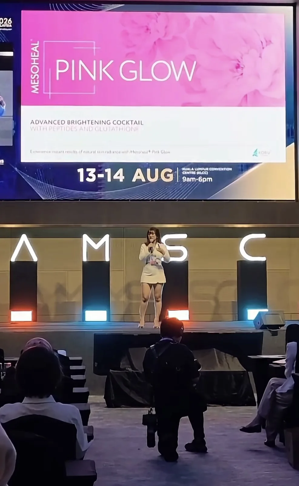 Dr. Garima presenting on stage at AMSC Kuala Lumpur, Malaysia, in August 2026